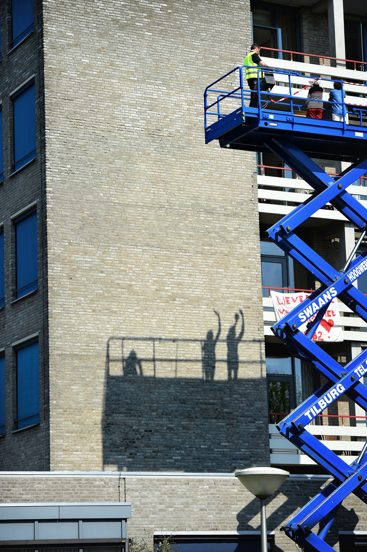 Bewoners van verpleeghuis Van Neynsel in Den Bosch worden verrast door bezoek op een hoogwerker. Beeld Marcel van den Bergh / de Volkskrant