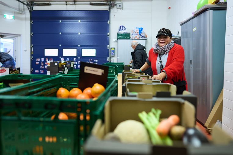 Vrijwilligers tellen voedselpakketten samen in de voormalige slagerij. Beeld Phil Nijhuis