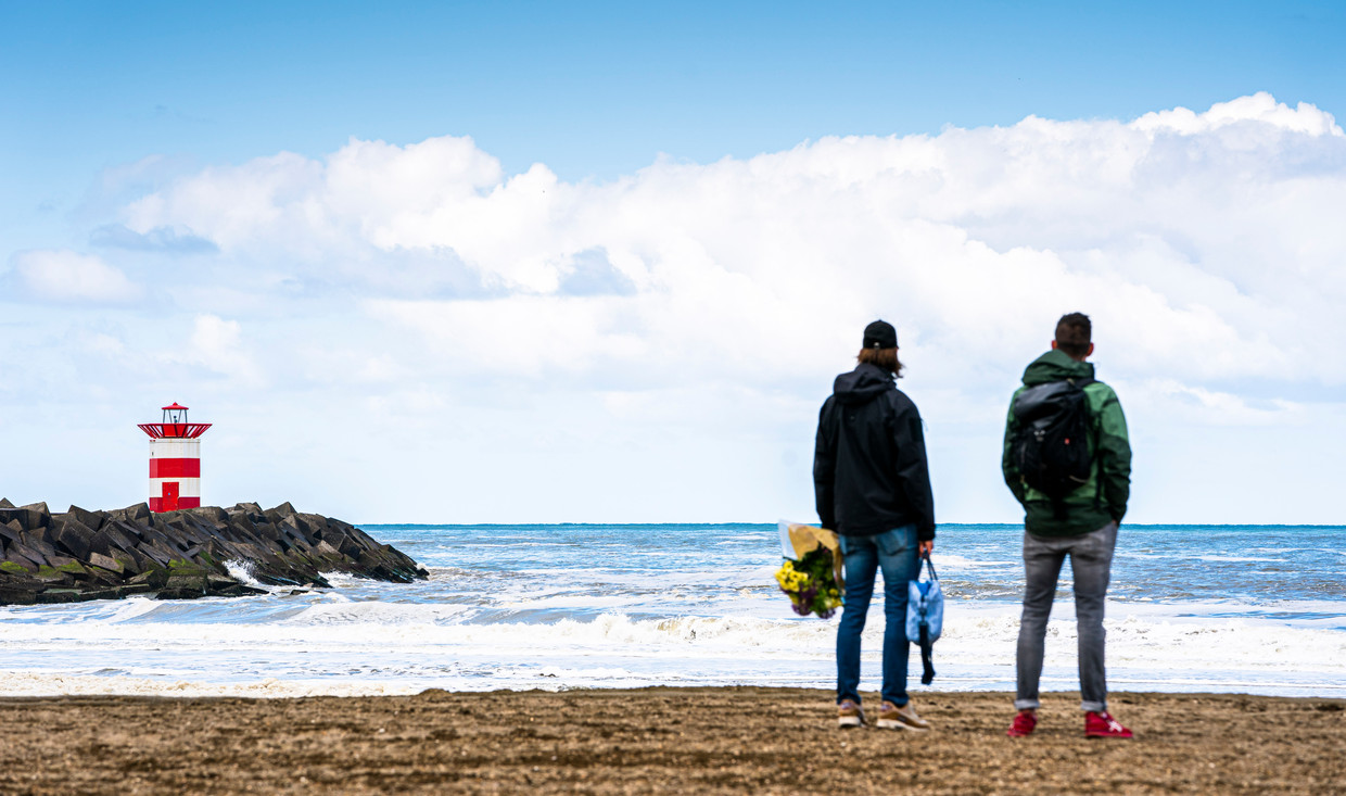 Belangstellenden op het strand van Scheveningen, met zicht op het Noordelijk Havenhoofd. Beeld Freek van den Bergh / de Volkskrant
