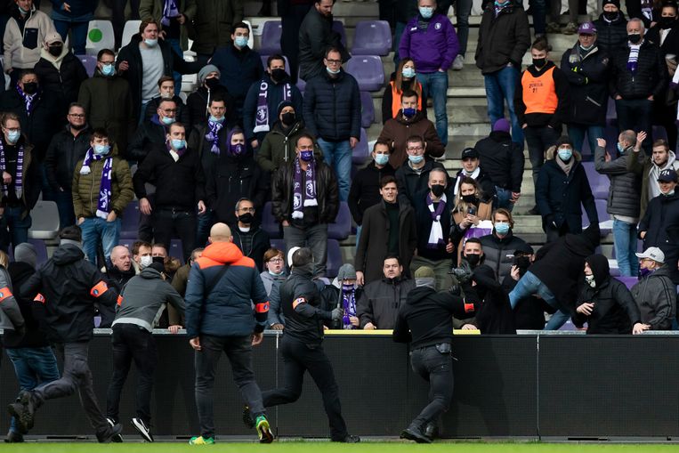 Agenten van de arrestatieteams achtervolgen de vluchtende hooligans van Beerschot tot in de tribune. Beeld BELGA