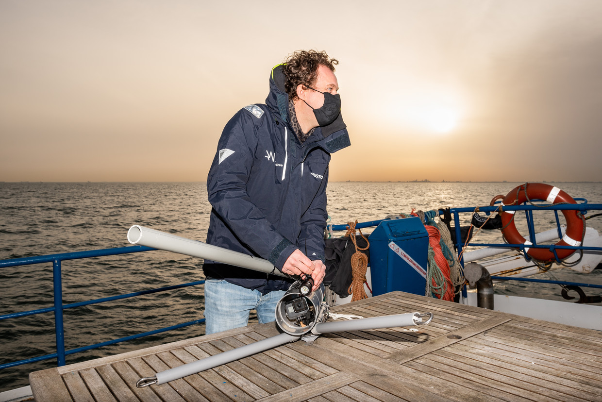 Christiaan van Sluis bevestigt een GoPro-camera op een installatie om op de zeebodem te kunnen filmen.  Beeld Simon Lenskens