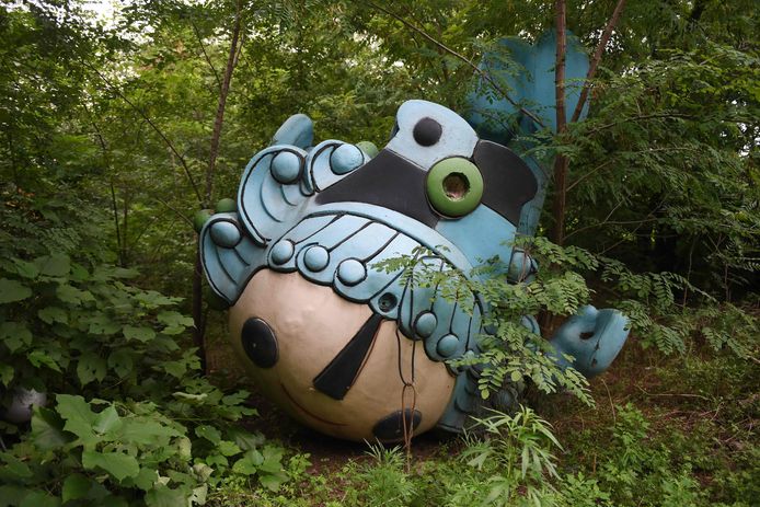 Nog een andere mascotte, Beibei, ligt verlaten tussen de bomen, achter een verlaten, nooit afgemaakt shoppingcenter in Beijing.