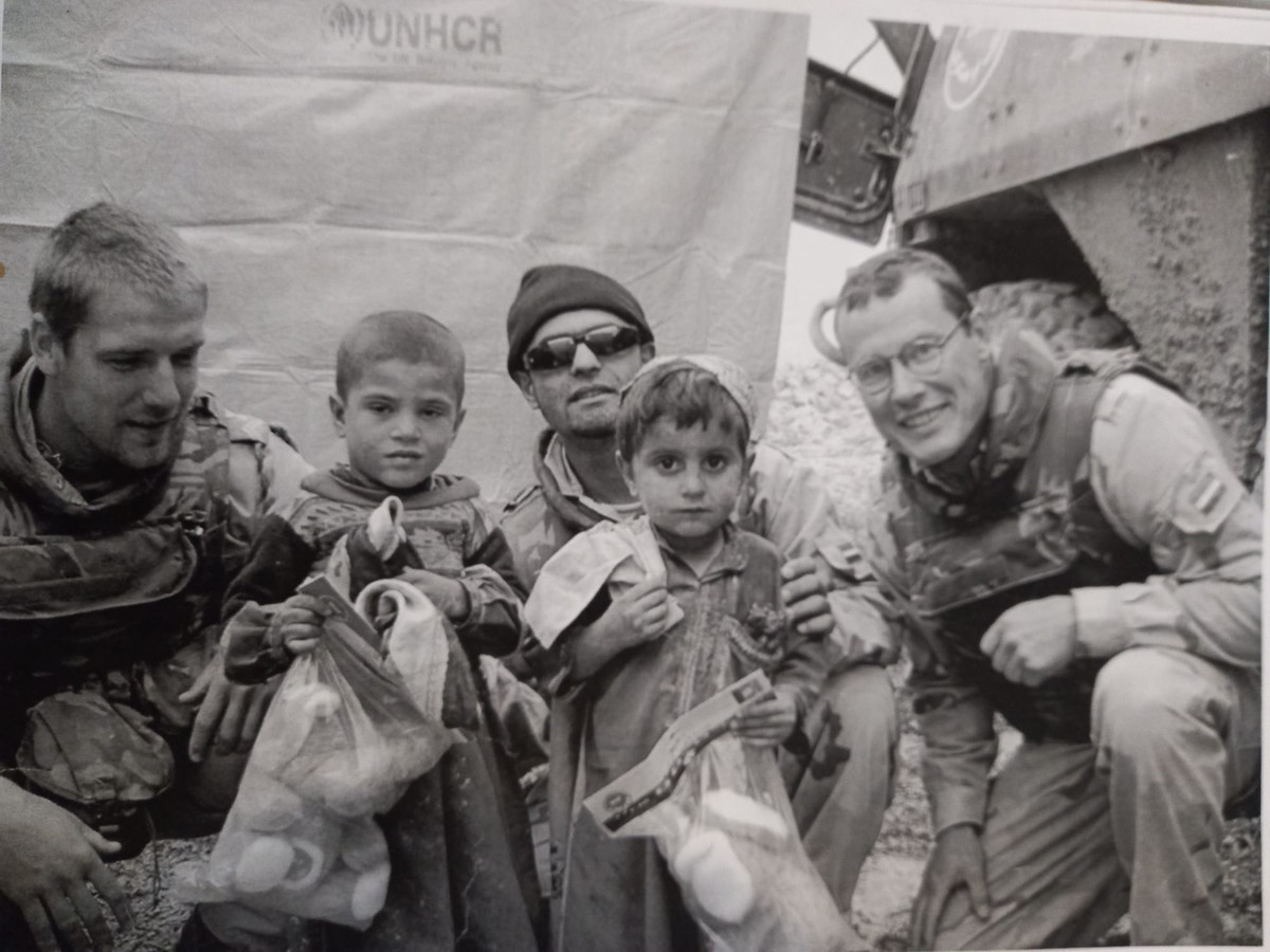 Agha Sherin Abdul Rahim (midden) tussen Nederlandse militairen en Afghaanse kinderen. Hij werkte als tolk voor het Nederlandse leger in Tarin Kowt in Uruzgan