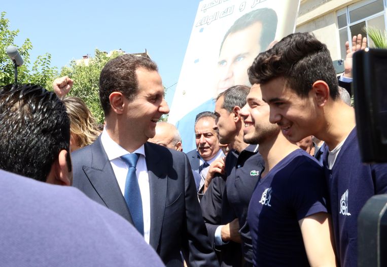 De Syrische president Bashar Assad praat vandaag met burgers nadat hij zijn stem heeft uitgebracht in een stembureau in Douma, vlakbij de hoofdstad Damascus.  Beeld Youssef Badaw / EPA