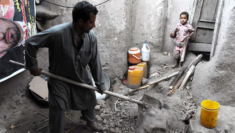 Een man ruimt puin in zijn geruïneerde woonst in Jalalabad, Afghanistan. Beeld epa