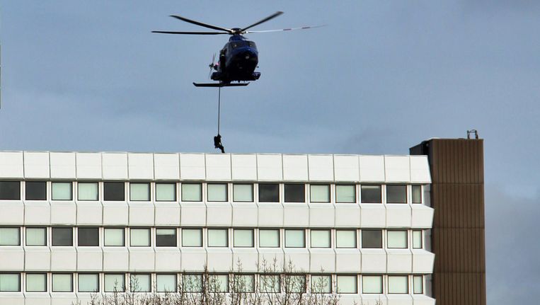 Militairen hangen aan een helikopter boven het oude CBS-gebouw in Voorburg. Het betreft een oefening, vermoedelijk voor de Nuclear Security Summit die in maart in Den Haag wordt gehouden. Beeld anp