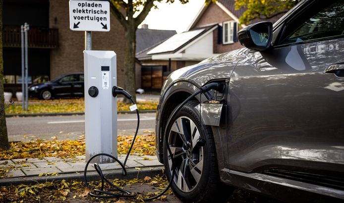Een elektrische auto wordt opgeladen aan een laadpaal.