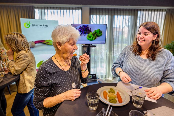 Bewoner Toos Nuijten en verpleegkundige Melissa Raats proberen de 3D-geprinte groenten uit in verzorgingshuis Leonardushof in Wouw.