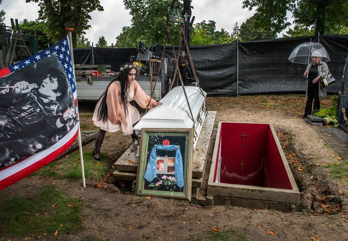 De kist van de onlangs overleden Cor Vermeulen op begraafplaats Zuylen wordt onder toeziend oog van zijn dochter Lisa-Marie (l) en vrouw Willeke verplaatst naar een tijdelijk onderkomen. De grafkelder was door hevige regenval gaan drijven en moet worden hersteld.