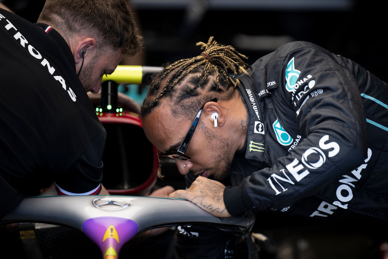 Lewis Hamilton bekijkt zijn Mercedes.