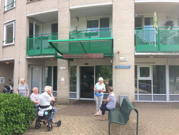 Bewoners van seniorenflat Nieuw Plettenburgh maken een praatje voor de entree van hun gebouw. 's Avonds blijven ze binnen, want dan vinden ze de straat te onveilig.