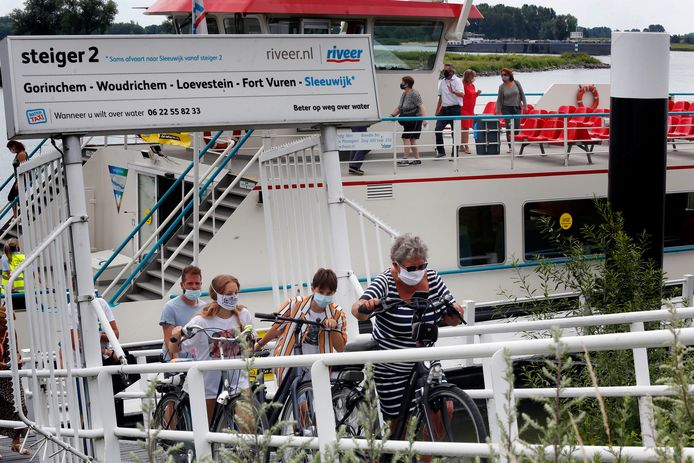 Passagiers met een mondkapje verlaten het veer. Foto ter illustratie. Geen van de personen op de foto heeft iets met de beledigingszaak te maken.