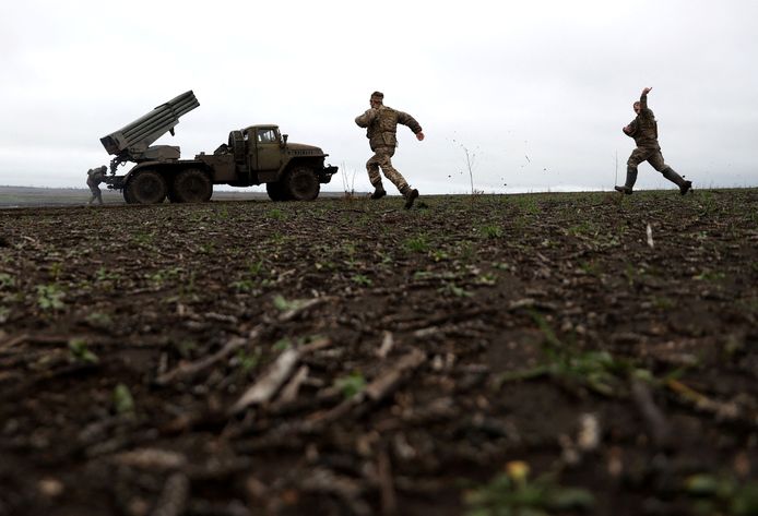 Украинские солдаты спешат к своим ракетным установкам после обстрела российских позиций под Пакмутом.