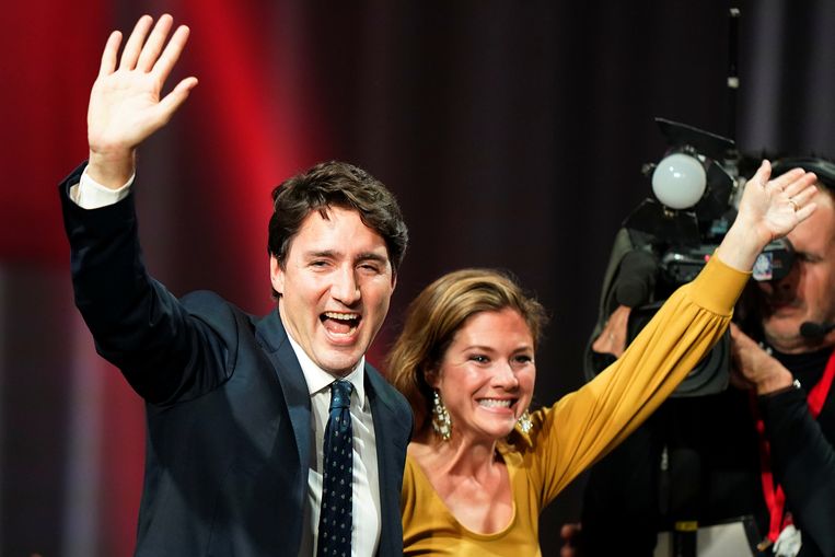 Justin Trudeau en zijn echtgenote Sophie zwaaien naar aanhangers nadat de verkiezingsuitslag heeft uitgewezen dat hij mogelijk opnieuw als premier van Canada aan de slag kan.  Beeld REUTERS