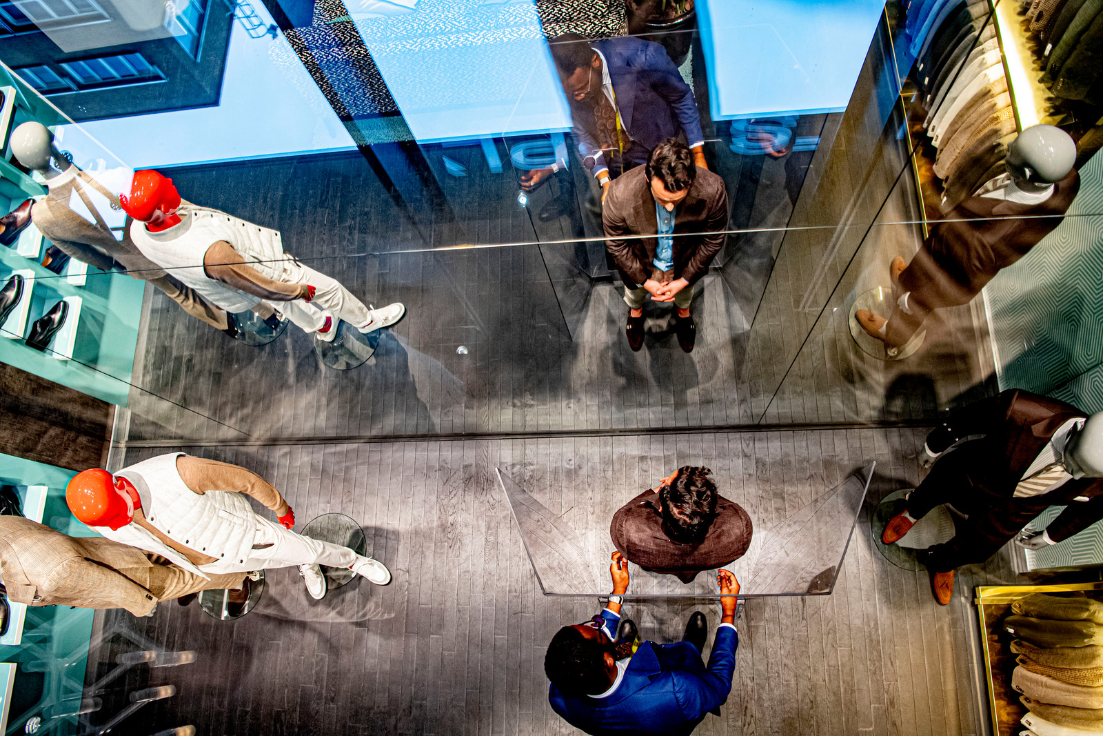 Bij Suitsupply wordt wél coronaproof gewerkt: grote plexiglas-kamerschermen waar de verkoper zijn handen doorheen steekt. Beeld Hollandse Hoogte / Robin Utrecht