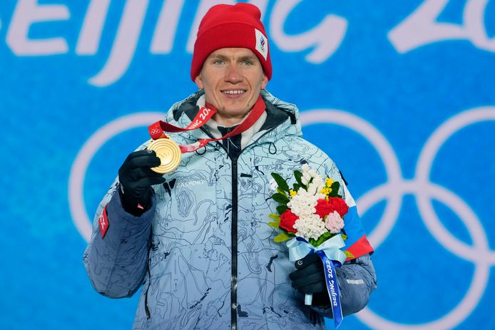 Aleksander Bolsjoenov toont zijn gouden medaille van de skiatlon.