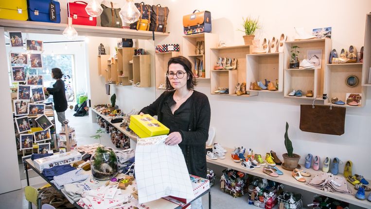 Tina Daem, de uitbaatster van een kinderschoenenwinkel maakt pakjes klaar voor online verkoop. Beeld Bas Bogaerts