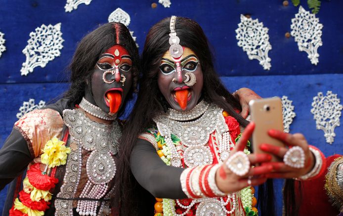Twee Indiase meisjes nemen, verkleed als hindoegodin Kali, een selfie tijdens een processie bij het Mahashivratri-festival in Allahabad. Foto Rajesh Kumar Singh