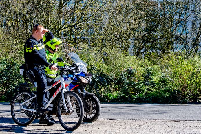 Politieagenten controleren of mensen zich houden aan de regel om anderhalve meter afstand te houden. Foto ter illustratie.