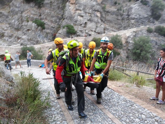 Een gewonde wordt weggedragen. De slachtoffers bevonden zich in een kloof in Calabrië. Daar deed zware regenval het water in een riviertje stijgen.
