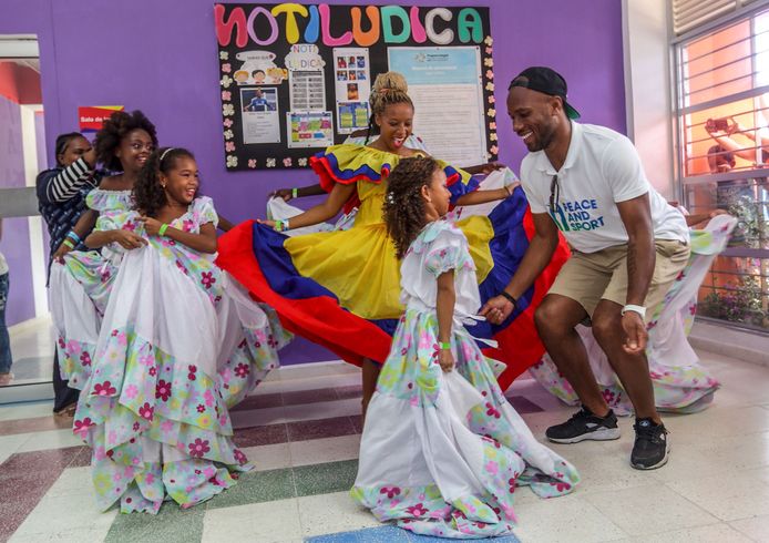 De voormalige Ivoriaanse topvoetballer Didier Drogba doet een Cumbia dans samen met Colombiaanse kinderen uit Cartagena. Foto Cesar Caprion