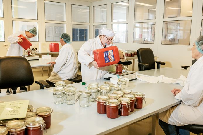 Ketchup wordt overgegoten in een sociale werkplaats in Schiedam, waar medewerkers de producten inpakken.