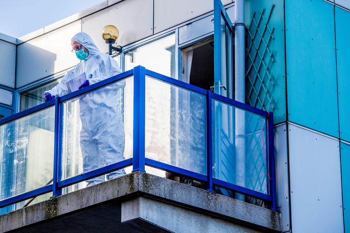 Forensisch medewerkers van de politie doen onderzoek op het balkon waar het lichaam van de pasgeboren baby is gevonden.