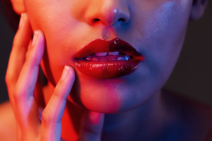 Cropped shot of a woman's lips under red lighting