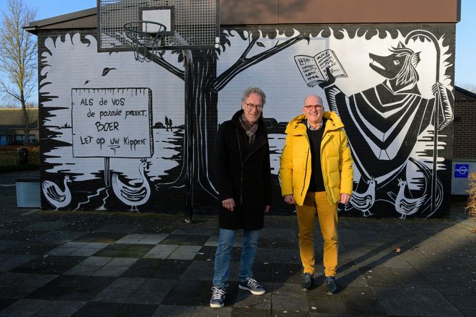Paul Cornelis (HulstArt) en initiatiefnemer Frank van Driessche voor de met streetart verfraaide gevel van dorpshuis Brandershole in Terhole.