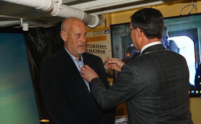 Burgemeester Bas van den Tillaar speldt de Zilveren Vlissingse Fles op de revers van Niek Peters.