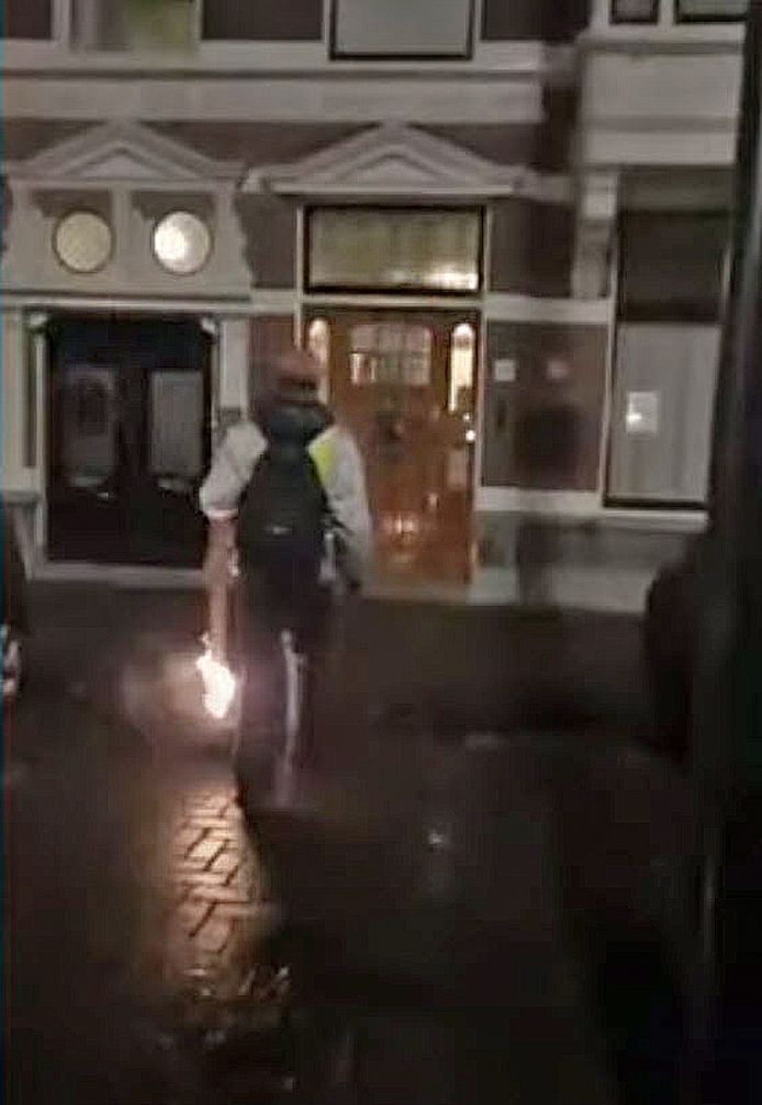 Activist Max van den Berg met een brandende fakkel bij het huis van Sigrid Kaag in Den Haag op 05-01-2021.