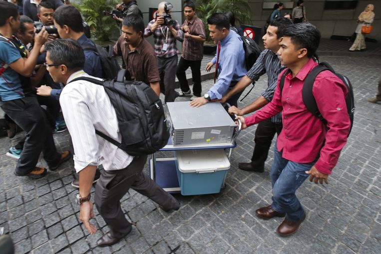 Politiemannen voeren belastend materiaal af na een inval in het kantoor van 1MDB. Via dat investeringsfonds zouden premier Razak en zijn vrouw zichzelf hebben verrijkt. Beeld EPA