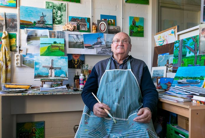 Ad de Hart in zijn atelier tussen de schilderijen van de omgeving Heusden en Herpt.