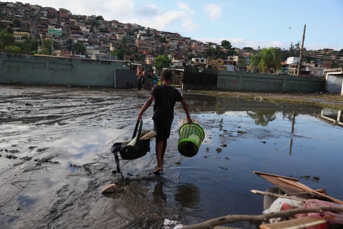 Een kind draagt spullen in een ondergelopen gedeelte van Rio de Janeiro, Brazilië. (14/01/24)