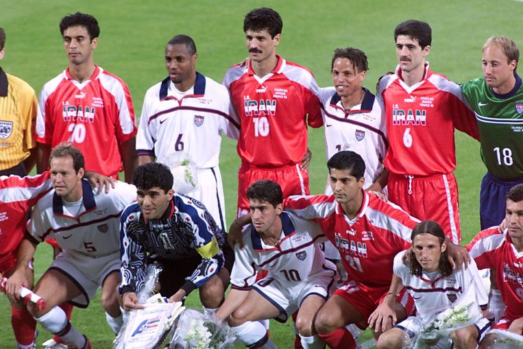 Op het WK 1998 poseren de Amerikaanse en Iraanse voetballers arm in arm, om hun onderlinge bondgenootschap te onderstrepen. Beeld AFP