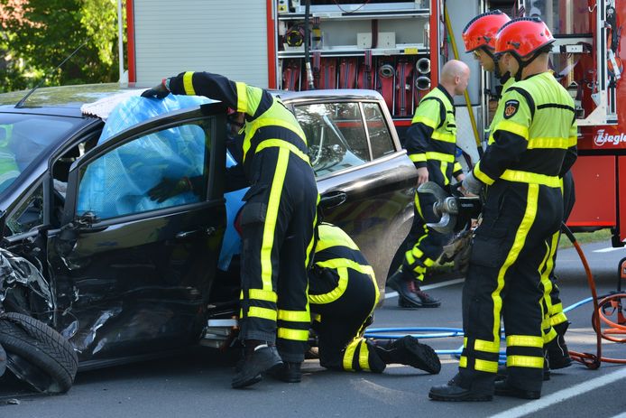 De brandweer bevrijdt de beknelde vrouw uit haar auto in Breda.