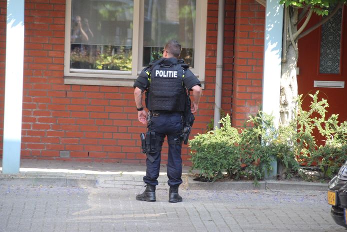 Zwaarbewapende agenten bewaken woning in Kwintsheul waar vuurwapens werden aangetroffen.