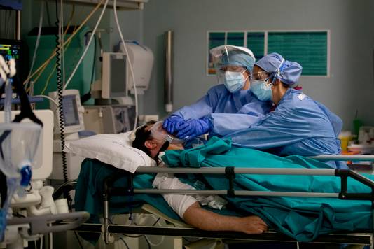 Verplegend personeel bij een coronapatiënt in een ziekenhuis in Milaan. Italië is hard getroffen door de coronapandemie. 
