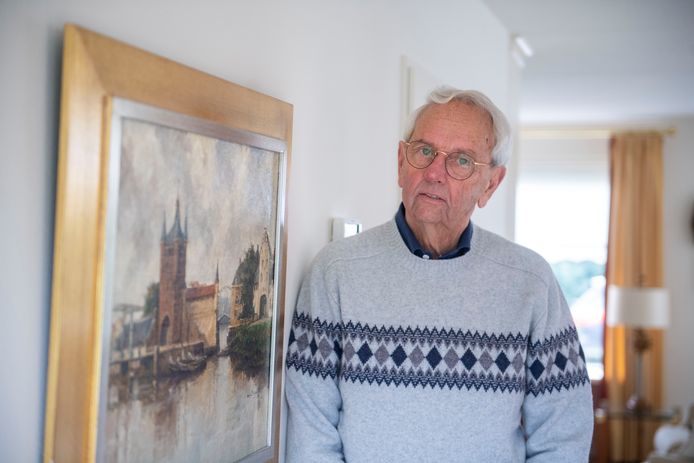 Bert Sies bij een schilderij met de oude waterpoort van Zierikzee, dat in Almelo in zijn kamer hangt.