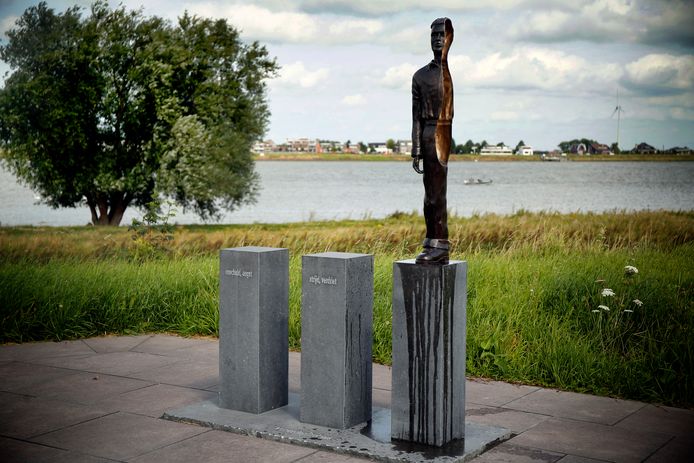 Het monument voor de Merwedegijzelaars aan de Sasdijk in Werkendam. Het bierflesje is inmiddels weggehaald.