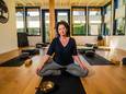 Cindy Woesthuis op de yogamat in haar Needse studio.