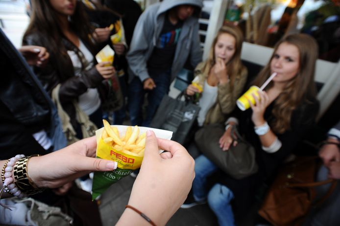 Jongeren genieten van een patatje bij de FEBO in Amsterdam.