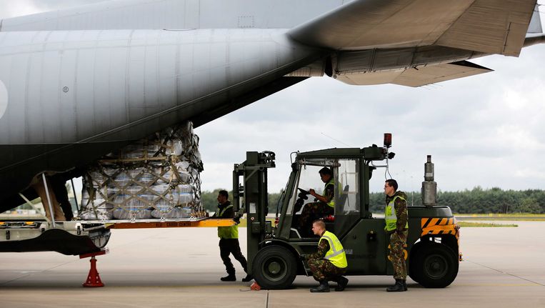 Een transportvliegtuig van de Koninklijke Luchtmacht wordt op vliegbasis Eindhoven geladen met hulpgoederen voor Noord-Irak. Beeld ANP