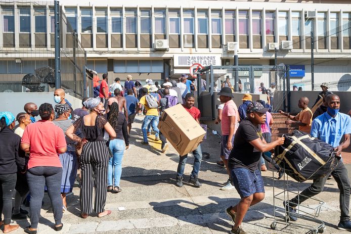 Plunderaars gaan aan de haal met spullen uit een winkel in Durban.