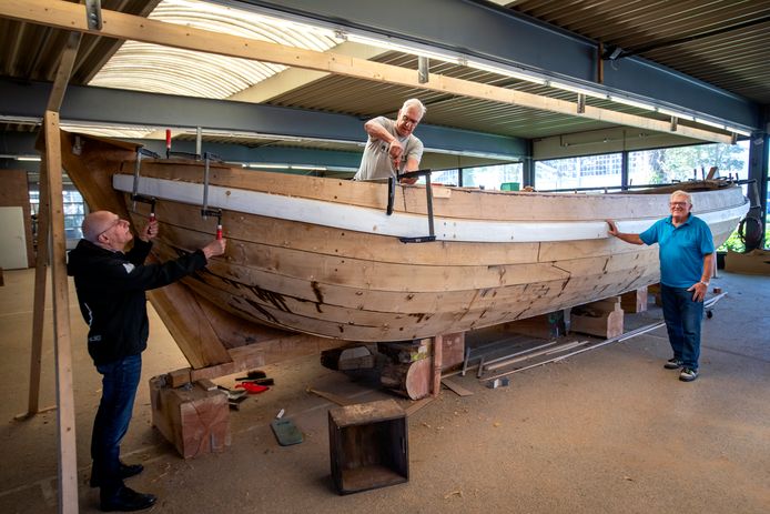 De bouw van de historische trekschuit Den Eerste Snik ligt op schema: het casco van de boot is klaar. Vrijwilligers Wim (links) en René zijn hard aan het werk. Frank Baart, voorzitter van de stichting Zorg en Vlijt, kijkt trots toe.