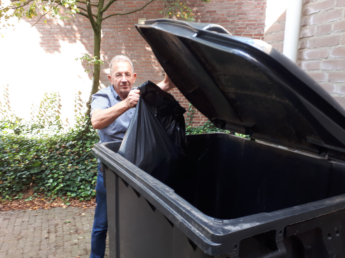 Jan Oliemeulen bij een van de grote afvalcontainers voor de aanleunwoningen. ,,Veel bewoners kunnen die zware klep niet optillen en tegelijk de vuilniszak erin gooien."