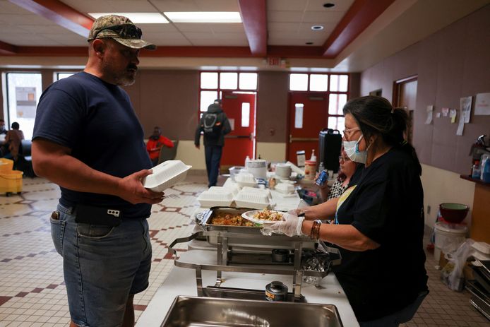 In een evacuatiecentrum wordt voedsel uitgedeeld aan mensen die hun woning moesten verlaten.