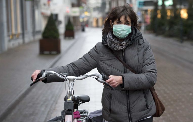 Een Nederlandse vrouw loopt rond met een mondmasker in het midden van de stad. Beeld ANP