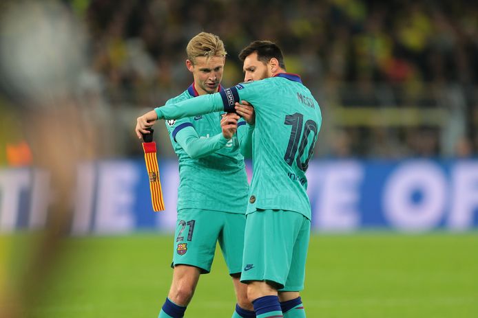 Frenkie de Jong doet de aanvoerdersband om de arm van Lionel Messi.