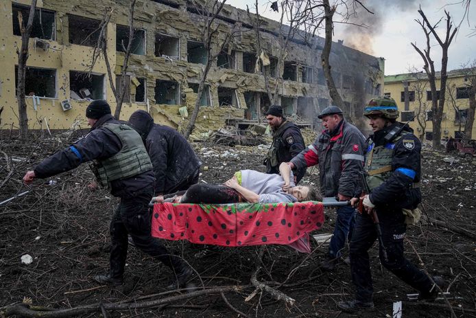 Een zwangere vrouw wordt uit een gebombardeerd ziekenhuis gehaald in Marioepol.